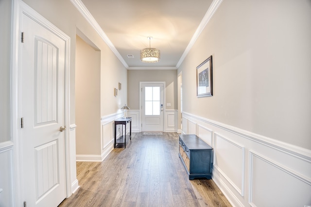 doorway with hardwood / wood-style flooring and ornamental molding