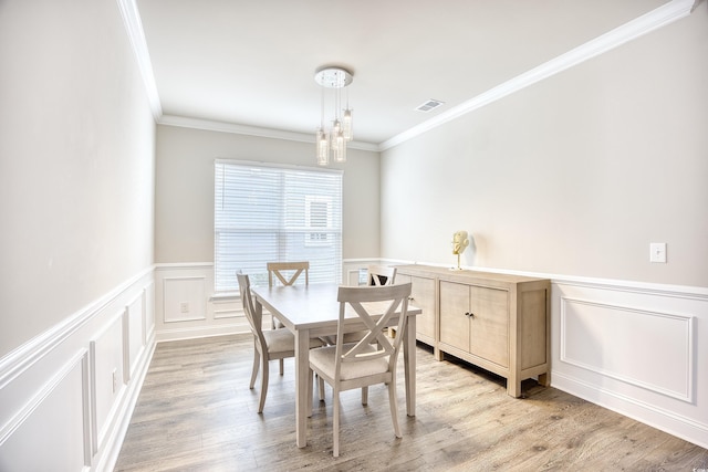 dining room featuring crown molding, a chandelier, and light hardwood / wood-style flooring