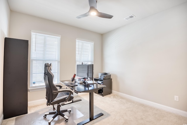 carpeted home office featuring ceiling fan