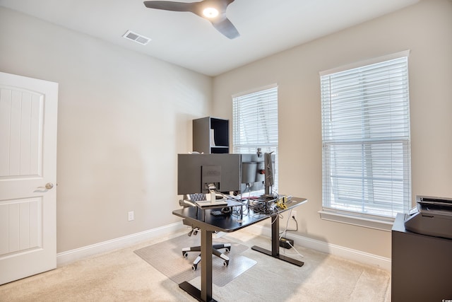 carpeted home office featuring ceiling fan