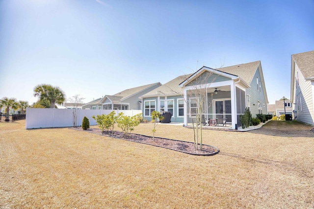 back of house with ceiling fan, a yard, a patio area, and a sunroom