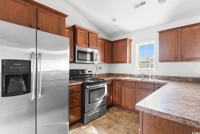 kitchen featuring appliances with stainless steel finishes, sink, and lofted ceiling