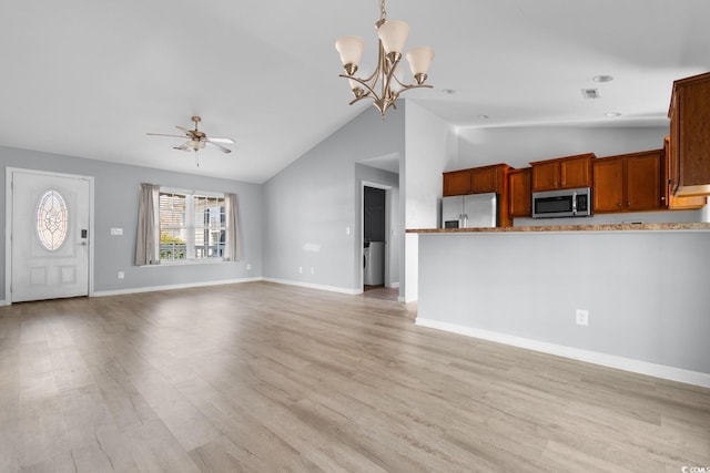 unfurnished living room featuring lofted ceiling, ceiling fan with notable chandelier, and light wood-type flooring