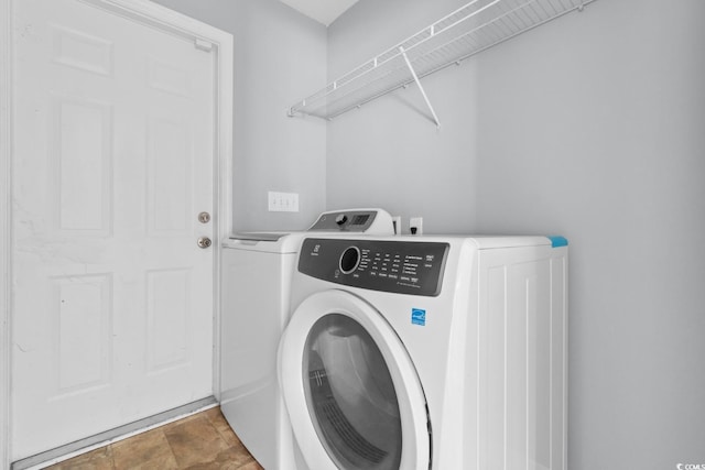 clothes washing area with washing machine and dryer