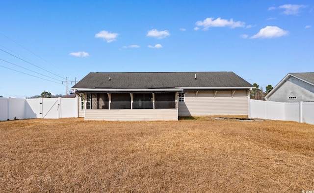 rear view of property with a sunroom and a lawn