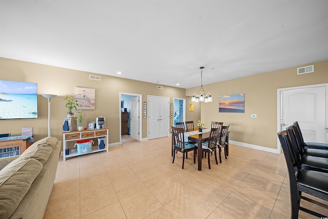 dining area featuring an inviting chandelier, light tile patterned flooring, visible vents, and baseboards