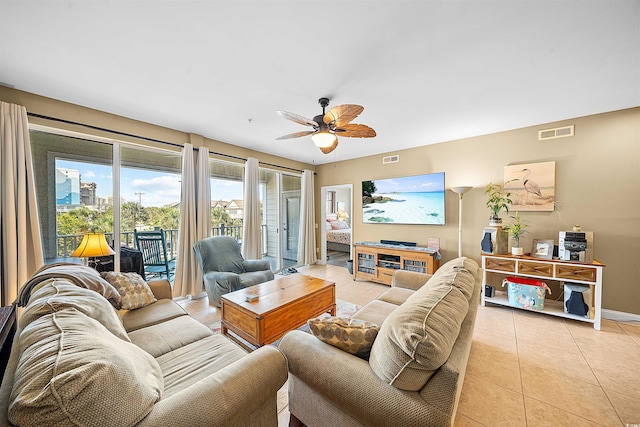 living room with light tile patterned floors, baseboards, visible vents, and a ceiling fan