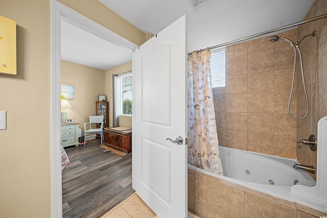 full bath with tiled shower / bath and wood finished floors