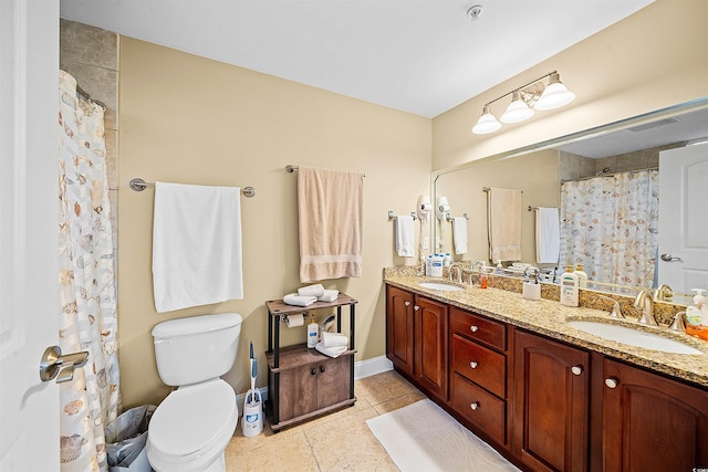 full bathroom with double vanity, a sink, toilet, and tile patterned floors