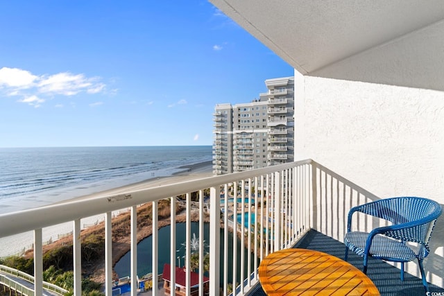 balcony featuring a beach view and a water view