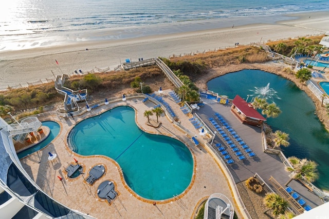 drone / aerial view featuring a water view and a view of the beach