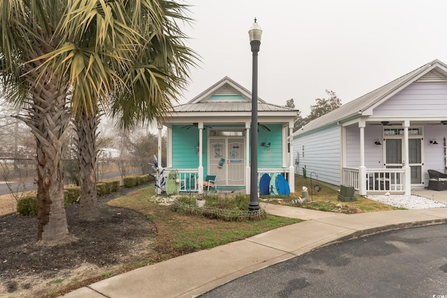 shotgun-style home with metal roof, a porch, and a ceiling fan