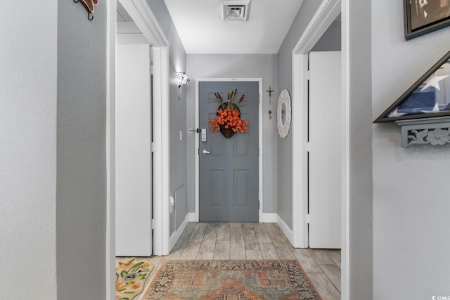 entryway featuring baseboards, visible vents, and wood tiled floor