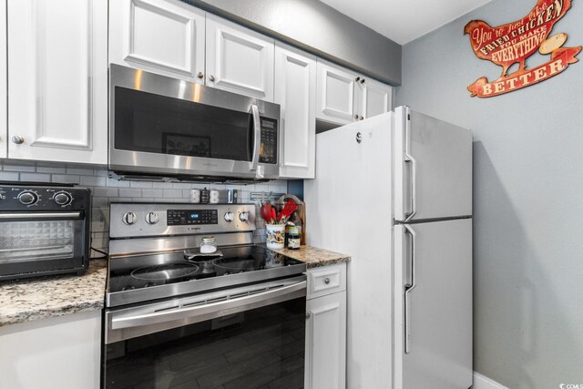 kitchen featuring white cabinetry, backsplash, light stone counters, and stainless steel appliances