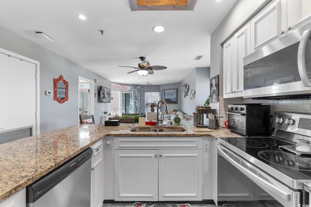 kitchen featuring white cabinetry, sink, light stone counters, and stainless steel appliances