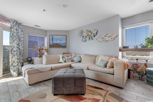 living area featuring wood finish floors, visible vents, and a healthy amount of sunlight