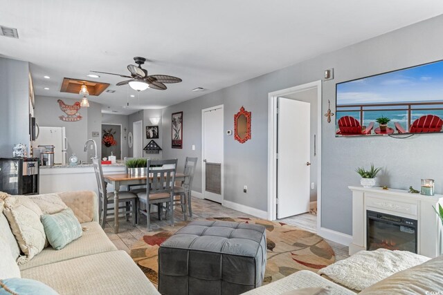 living room featuring ceiling fan and sink