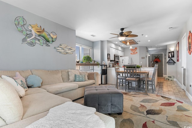 living area featuring recessed lighting, visible vents, ceiling fan, and baseboards