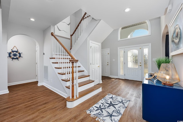 foyer entrance with hardwood / wood-style flooring and a towering ceiling