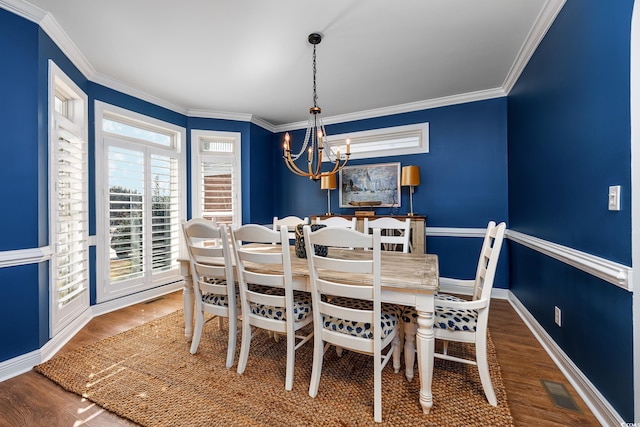 dining room featuring a notable chandelier, ornamental molding, and dark hardwood / wood-style floors