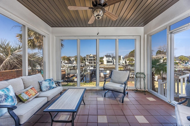 sunroom with a water view, wood ceiling, and ceiling fan