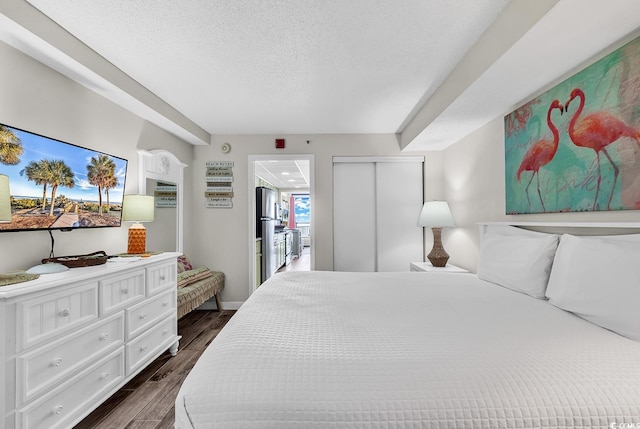 bedroom with dark wood-type flooring, a closet, and a textured ceiling