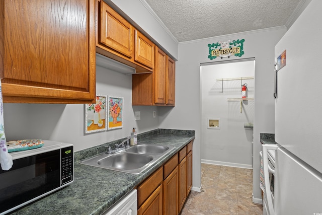 kitchen with white refrigerator, ornamental molding, sink, and a textured ceiling