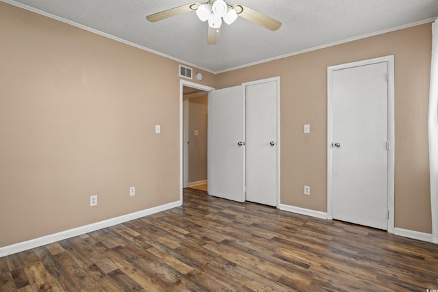 unfurnished bedroom with dark wood-type flooring, ceiling fan, ornamental molding, and a textured ceiling