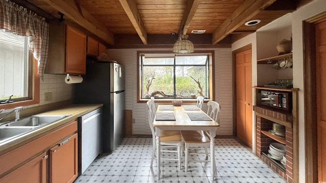 kitchen with sink, wood ceiling, appliances with stainless steel finishes, beam ceiling, and a kitchen breakfast bar