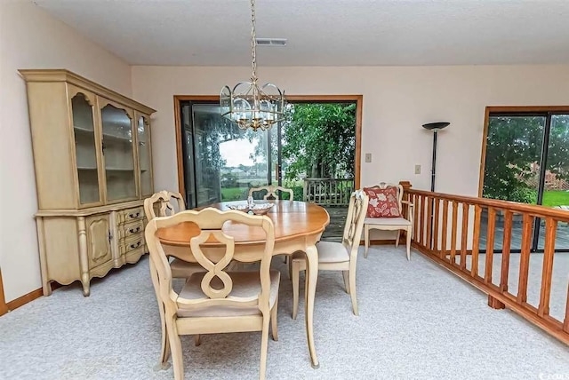 carpeted dining space featuring a chandelier