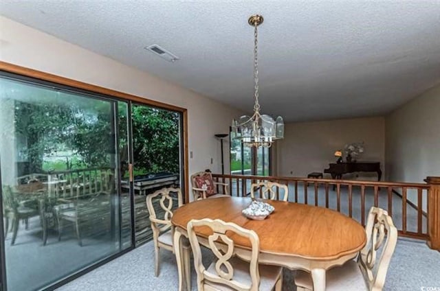 dining space featuring a notable chandelier, a textured ceiling, and carpet