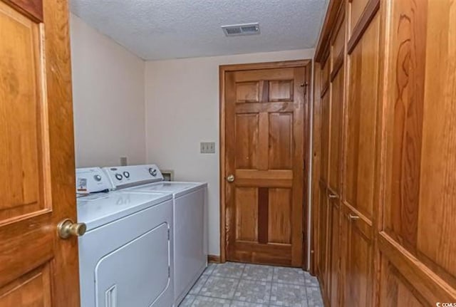 laundry area featuring independent washer and dryer and a textured ceiling