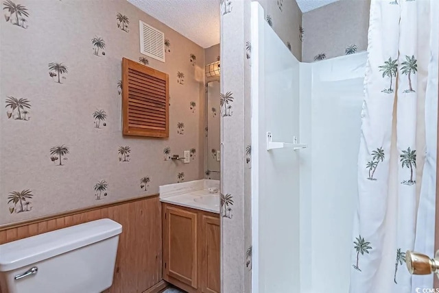 bathroom featuring vanity, toilet, and a textured ceiling