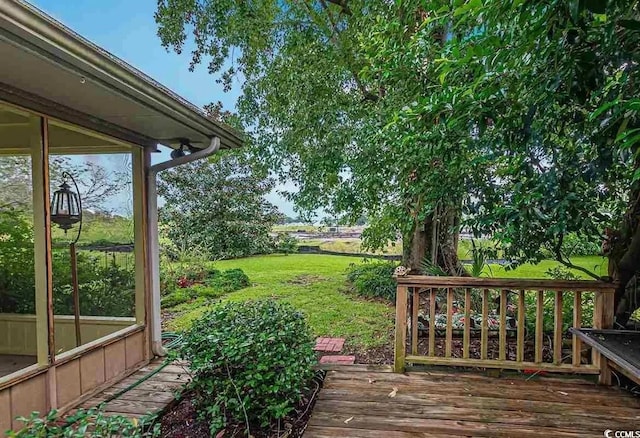 wooden deck with a yard and a sunroom