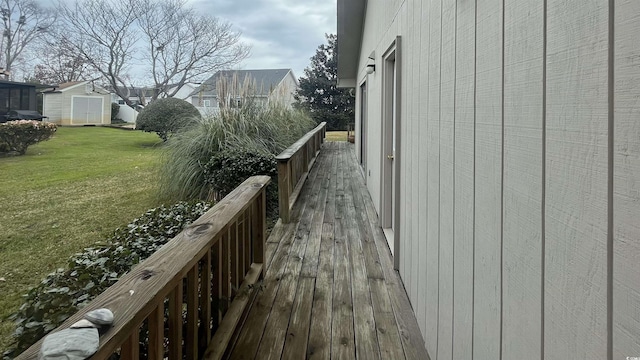 wooden deck with a yard and a storage shed