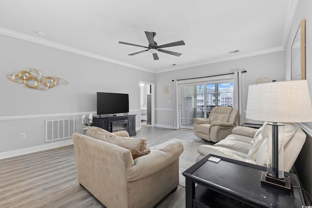 living room featuring crown molding, light hardwood / wood-style floors, and ceiling fan