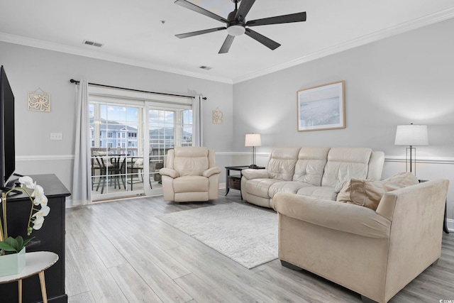 living room with crown molding, ceiling fan, and light hardwood / wood-style flooring