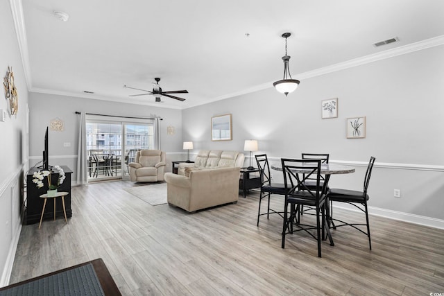 living room with ornamental molding, hardwood / wood-style floors, and ceiling fan