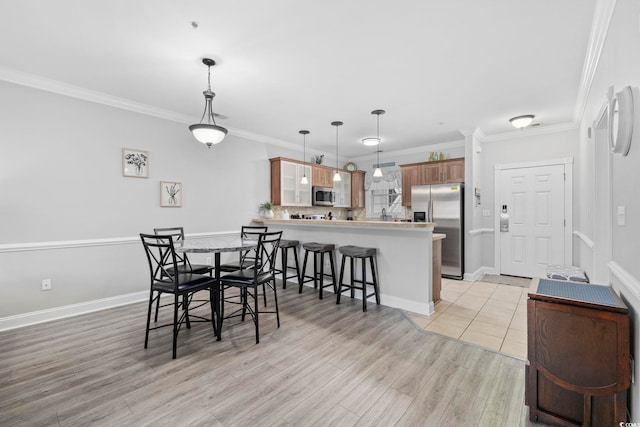 dining room featuring ornamental molding and light wood-type flooring