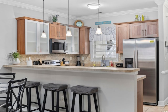 kitchen with stainless steel appliances, a kitchen breakfast bar, kitchen peninsula, and backsplash