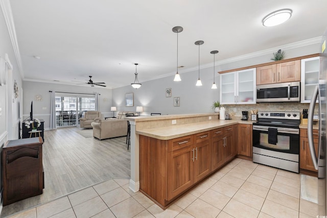 kitchen with light tile patterned flooring, tasteful backsplash, hanging light fixtures, appliances with stainless steel finishes, and kitchen peninsula