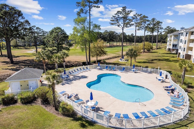 view of pool with a lawn and a patio