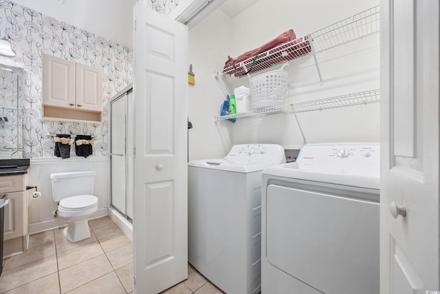 laundry area with separate washer and dryer and light tile patterned floors