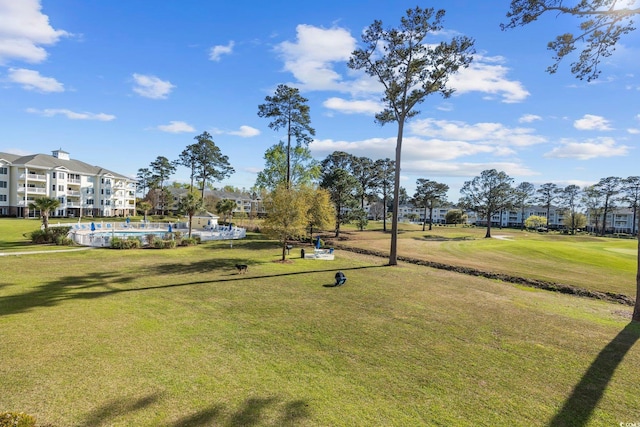 view of home's community with a swimming pool and a lawn