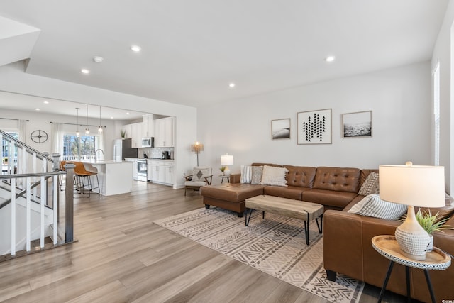 living room with light hardwood / wood-style floors and sink