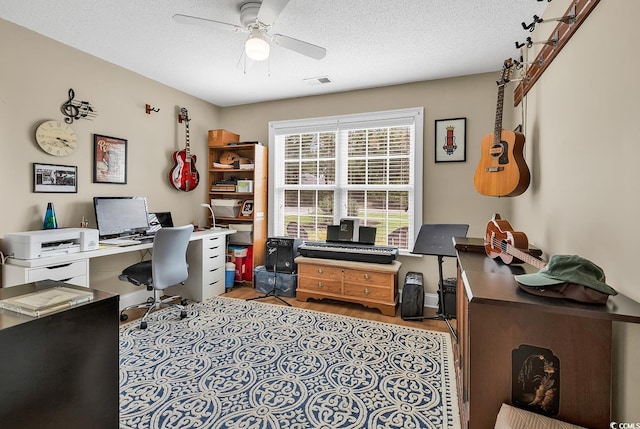 office space with ceiling fan, light hardwood / wood-style floors, and a textured ceiling