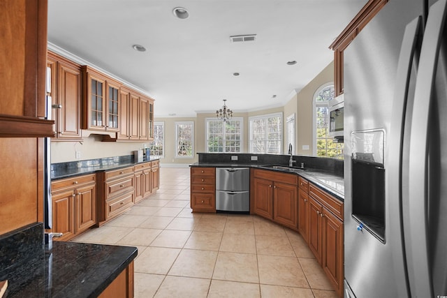 kitchen with light tile patterned floors, sink, stainless steel appliances, ornamental molding, and decorative light fixtures