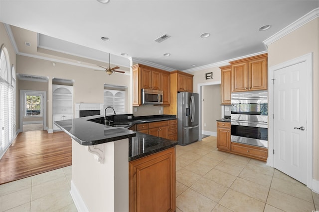 kitchen featuring light tile patterned floors, crown molding, a breakfast bar area, and appliances with stainless steel finishes