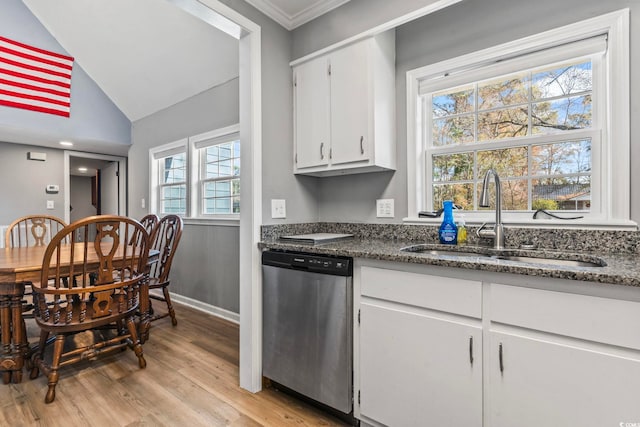 kitchen with sink, light hardwood / wood-style floors, white cabinets, vaulted ceiling, and stainless steel dishwasher