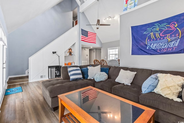 living room with hardwood / wood-style flooring, ceiling fan, and high vaulted ceiling